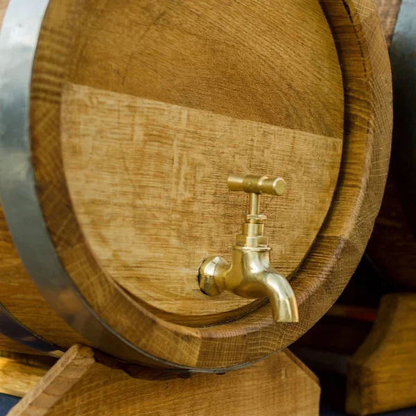 Barris de madeira para vinho com uma torneira de metal amarelo . — Fotografia de Stock