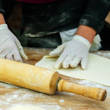 Gıda hazırlama. İnsan elinde eldiven hamur ürünleri olun. Rolli