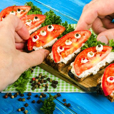 Taze domates ve maydanoz, kızarmış ekmek üzerinde. İnsan eli almak summ