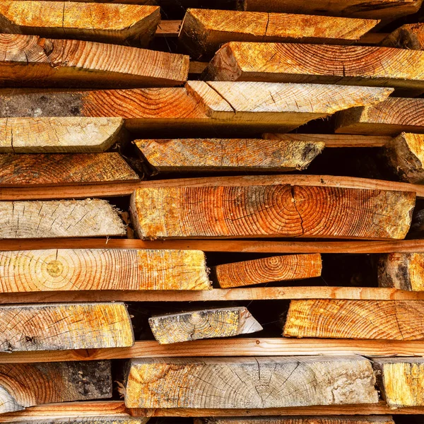 Stack of stacked Lumber. Dried wood boards with a crack. Differe