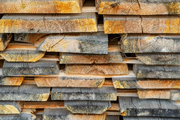 Stack of stacked Lumber. Dried wood boards with a crack. Differe