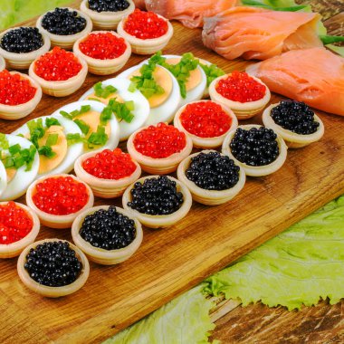 Kırmızı ve siyah havyar, somon, marul ile ev yapımı tartlets ve