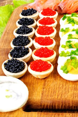 Kırmızı ve siyah havyar, somon, marul ile ev yapımı tartlets ve