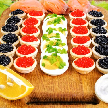 Kırmızı ve siyah havyar, somon, marul ile ev yapımı tartlets ve