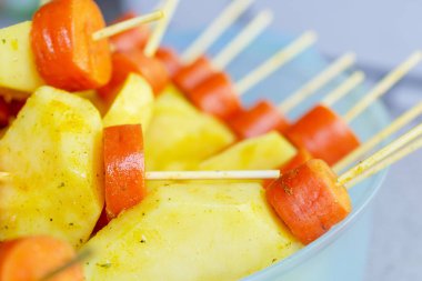 Çiğ havuç ve patates, bir şiş ızgara üzerinde sinirli. Prepa