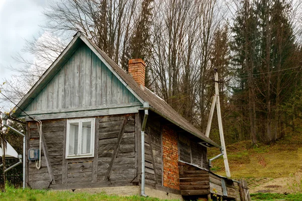 Старомодный деревянный дом на окраине леса. Среди — стоковое фото