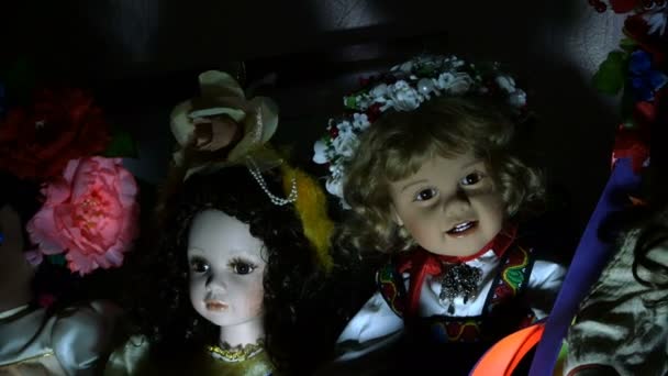 Varias muñecas en un estante de una antigua casa con una iluminación dramática, que parecen misteriosas y de otro mundo inspiran miedo. Primer plano . — Vídeos de Stock