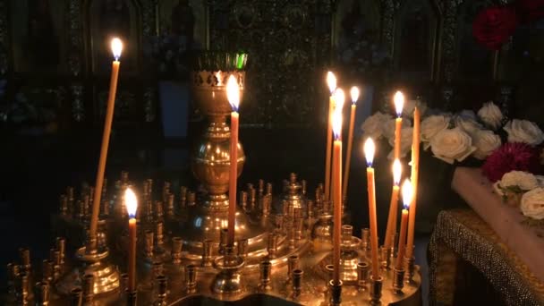 Veduta delle molte candele di cera che bruciano sull'altare nella cattedrale o chiesa oscura ortodossa o cattolica. Religione e concetto di fede Primo piano . — Video Stock