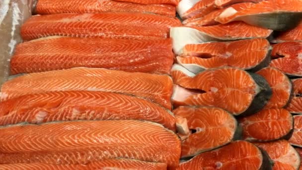 Fischladen. Frisches Filet, gehackter roher Lachs, in Stücke geschnitten liegt auf der Ladentheke zum Verkauf. Lebensmittel-Hintergrund. Nahaufnahme. — Stockvideo