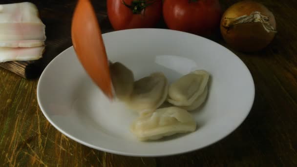 Fresh boiled homemade dumplings or vareniki with stuffing. With hot steams. Impose in white plate. Served with fried onion and lard. Ukrainian and russian national cuisine. Close-up. — Stock Video
