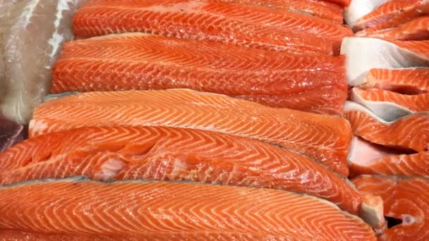 Fischladen. Frisches Filet, gehackter roher Lachs, in Stücke geschnitten liegt auf der Ladentheke zum Verkauf. Lebensmittel-Hintergrund. Nahaufnahme. — Stockvideo