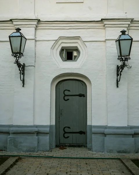 Old-style closed wooden doors in a stone wall which are adorned