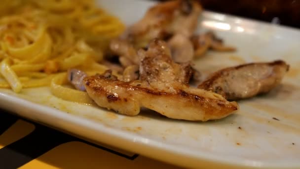 Spaghetti met saus en gebakken vlees worden gegeten met een metalen vork van witte schotel. Selectieve focus. — Stockvideo