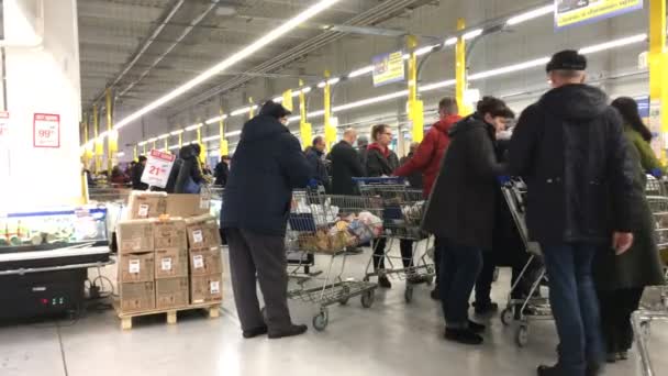 Kiev, Ukraine, December 2019: - Retail in food market. Many shoppers with shopping trolleys line up at checkout counter in supermarket or store. Overall plan. — Stock Video