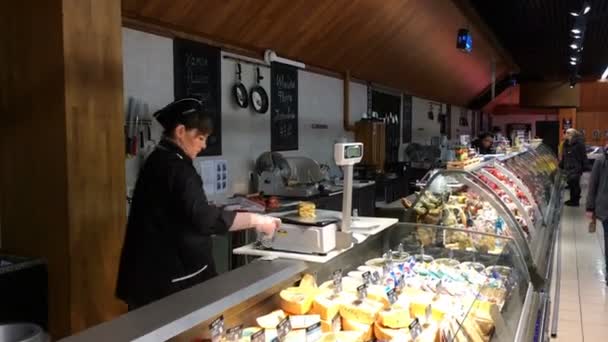 Kiev, Ukraine, janvier 2020 : - La vendeuse d'origine caucasienne en uniforme pèse le fromage dans le département des produits laitiers de l'épicerie. Travail de vendeur au supermarché. Plan moyen . — Video