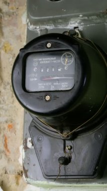 Tüketilmiş elektriği hızlı dönen bir disk ve eski konut binasında kilovat saatlerini ölçmek için dijital ekranla ölçmek için eski moda bir sayaç. Dikey çekim.