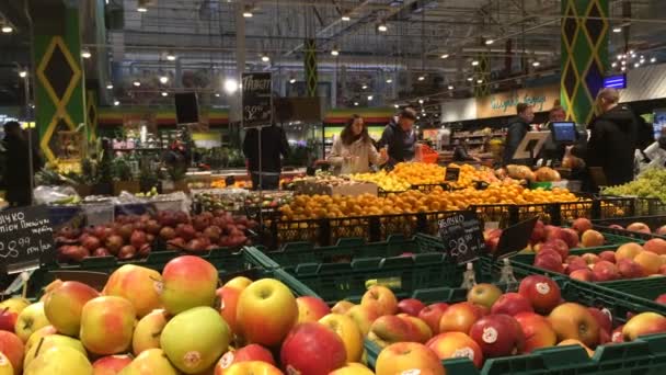 Kiev, Ucrania, julio de 2019: Los compradores eligen un producto y realizan compras en el departamento con frutas y verduras en un supermercado en un centro comercial en Kiev, Ucrania . — Vídeos de Stock