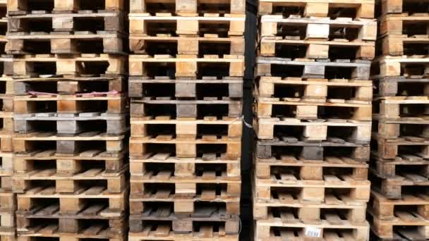 Muitas pilhas de paletes de madeira usadas do tipo euro no armazém estão prontas para reciclagem. Fundo industrial. Close-up . — Vídeo de Stock