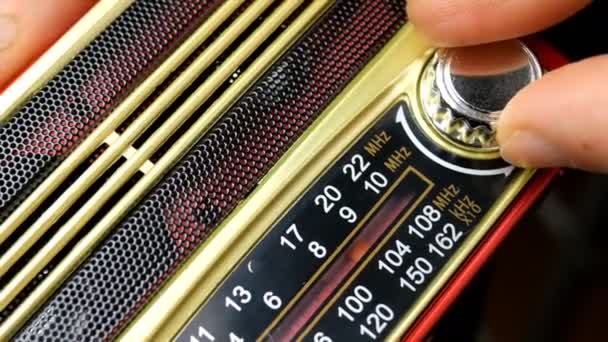 Руки людини пальцями регулюють налаштування старого радіо на радіохвилю. Вмикає або вимикає ручку у пошуках цікавої радіостанції. Крупним планом . — стокове відео