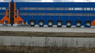 Depo yükleniyor. Modern lojistik merkezi. Yükler ve kamyonlar için kapıları olan bir dağıtım merkezinin yanaşma istasyonları.