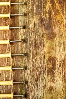 Metal vidaları olan birçok plastik panel çizik bir tahta masanın üzerinde bir sırada yatıyor. Ev onarımı konsepti. Uzayı metin için kopyala. Dikey format. Yakın plan..