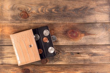 Yanında bir sent ve çeyrek dolar olan açık bej ya da kahverengi deri cüzdan. Ekonomik kriz, yoksulluk, parasızlık. Ahşap arka planda ya da masada. Düz yatıyordu. Üst Manzara. Yakın plan..