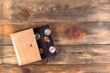 Yanında bir sent ve çeyrek dolar olan açık bej ya da kahverengi deri cüzdan. Ekonomik kriz, yoksulluk, parasızlık. Ahşap arka planda ya da masada. Düz yatıyordu. Üst Manzara. Yakın plan..