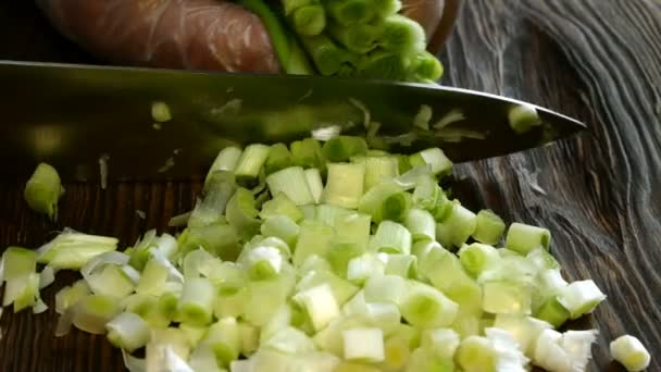 Готуємо яєчний салат з зеленою цибулею. Крок за кроком. Зелену цибулю нарізають на дерев'яну кухонну дошку . — стокове відео