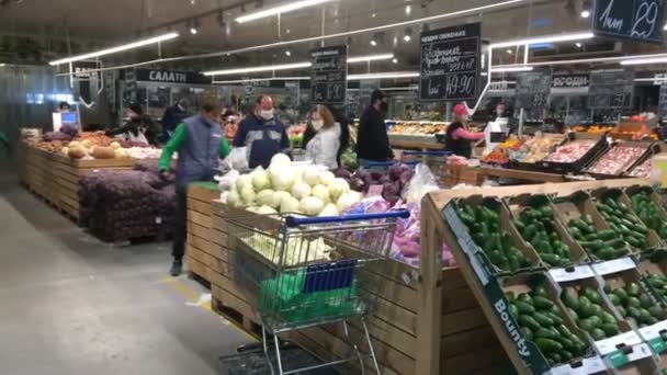 Kiev, Ucrania, febrero de 2020: Los compradores en máscara médica eligen y pesan productos en el departamento de verduras en el supermercado Metro durante la epidemia de coronavirus covid-19 en Kiev, Ucrania . — Vídeo de stock