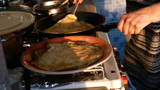 As mãos femininas fritam panquecas na panela de ato de fritar e lançam-nas, no fogão em casa na cozinha. Plano médio . — Vídeo de Stock