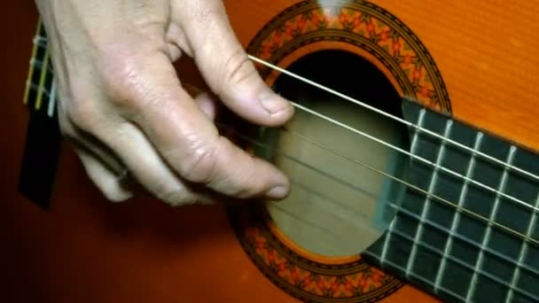 Fingers of human hand playing an acoustic wooden guitar fingering strings. — Stock Video