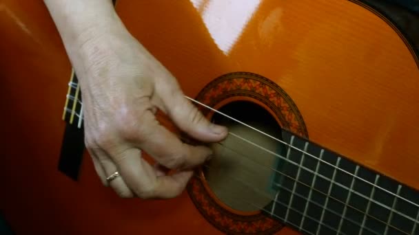 Dedos de mão humana tocando uma guitarra acústica de madeira dedilhado cordas . — Vídeo de Stock