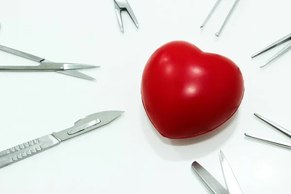 Καρδιά και τα χειρουργικά εργαλεία που απομονώνονται σε λευκό φόντο — Φωτογραφία Αρχείου