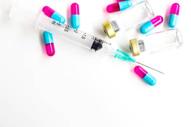 Beyaz zemin üzerinde iğne ve uyuşturucu kapsülü bulunan 3 ml plastik şırınga.