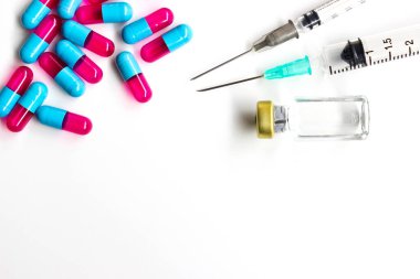 Beyaz zemin üzerinde iğne ve uyuşturucu kapsülü bulunan 3 ml plastik şırınga.