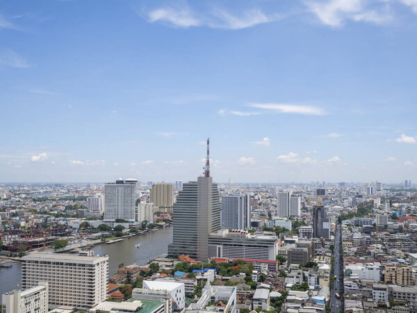 Cityscape and modern building near Chao Phraya River river in the afternoon at Bangkok, Thailand under blue sky and cloud