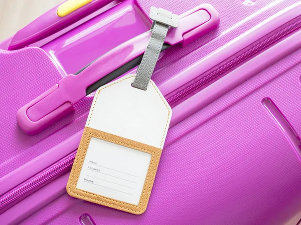 Gepäckanhänger auf rosa Koffer 1 — Stockfoto