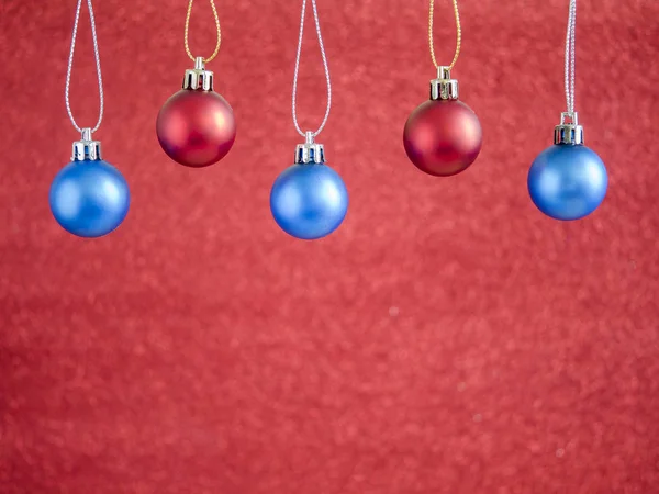 Red and blue christmas ball hang on red blur background 1 — Stock Photo, Image