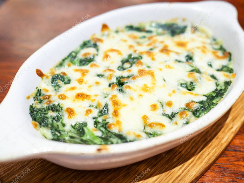 Closeup of Spinach with cheese on dish in the restaurant (Selective Focus)