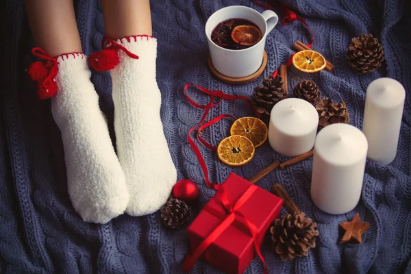 Pieds féminins et tasse de thé de Noël — Photo
