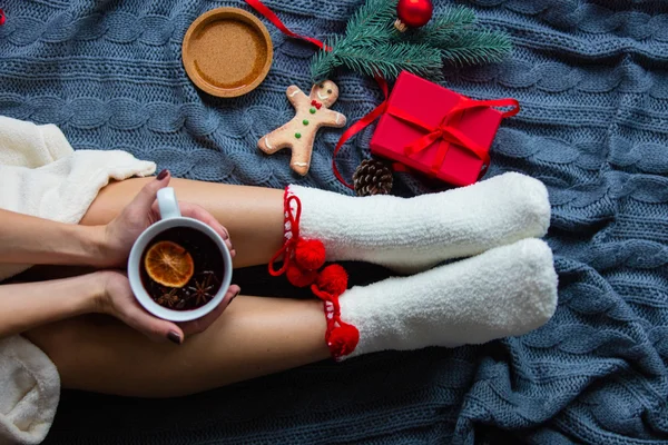 Pieds féminins et tasse de thé de Noël — Photo