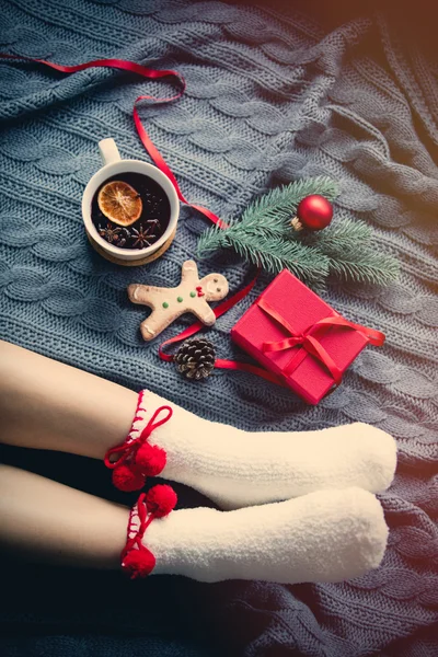 Pieds féminins et tasse de thé de Noël — Photo