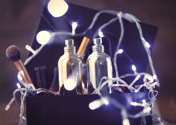 Luzes de fadas e garrafas de cosméticos — Fotografia de Stock