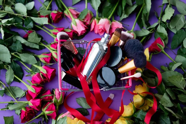 Rosa flores e cesta de compras com cosméticos — Fotografia de Stock