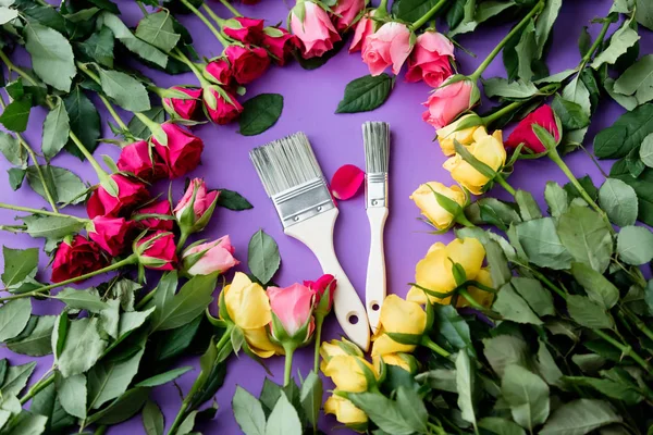 Roze bloemen en verf kwasten — Stockfoto