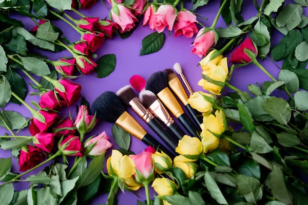 Rosa flores e pincéis de maquiagem — Fotografia de Stock