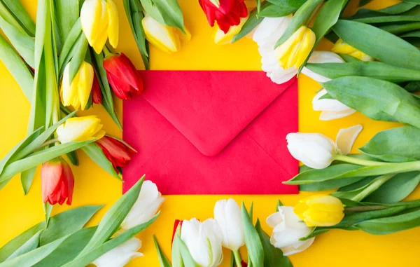 Разноцветный букет тюльпанов и конверт — стоковое фото