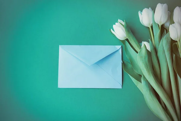 Букет и конверт из белых тюльпанов — стоковое фото