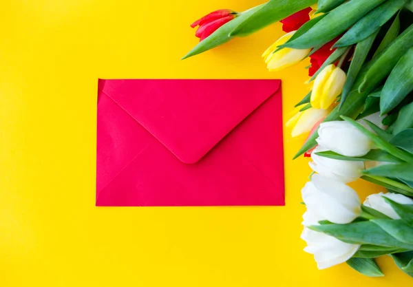 Разноцветный букет тюльпанов и конверт — стоковое фото