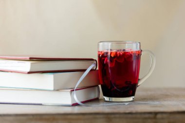 Fincan gül çayı ve kitaplar